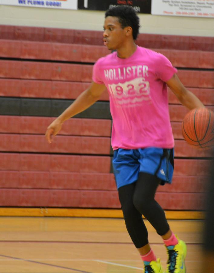 During basketball practice, senior Darreon Miller dribbles the ball. Miller has been a varsity player for over a year.